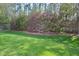 Lush backyard with green grass, flowering bushes, and mature trees at 1914 Woodsdale Dr, Durham, NC 27703