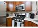 A gas range and stainless microwave complement the wood cabinetry of this bright kitchen at 1914 Woodsdale Dr, Durham, NC 27703