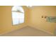 Bright bedroom featuring neutral carpeting, yellow walls, and a large arched window at 201 Blithe Pl, Morrisville, NC 27560