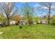 Green, tree-lined backyard with view of the rear of a light-colored single-story home at 229 Watson Dr, Burlington, NC 27217