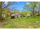 Landscaped backyard with trees, grass, and the back of a light-colored single-story home at 229 Watson Dr, Burlington, NC 27217