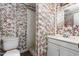 A full bathroom features patterned wallpaper, a toilet, a sink, and a shower at 229 Watson Dr, Burlington, NC 27217