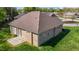 Aerial view of the brick home featuring a well maintained lawn, patio, and neutral shingles at 252 Shea Ct, Graham, NC 27253