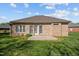 Home's backyard featuring a brick exterior, patio, and well-maintained lawn at 252 Shea Ct, Graham, NC 27253