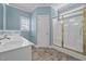 Bathroom with white cabinets, walk-in shower, and natural light at 252 Shea Ct, Graham, NC 27253