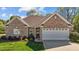 Charming brick home featuring a well-manicured lawn, arched window and attached two-car garage at 252 Shea Ct, Graham, NC 27253