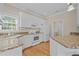 Charming kitchen with granite countertops, wooden floors, and white cabinetry at 252 Shea Ct, Graham, NC 27253