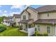 Exterior view of townhomes featuring covered patios, well-manicured lawns, and privacy fences on a sunny day at 265 Mariah Towns Way, Garner, NC 27529