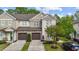 Charming townhome featuring a stone facade, two-car garage, and well-maintained landscaping at 265 Mariah Towns Way, Garner, NC 27529