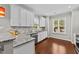 Kitchen featuring white cabinets, granite countertops, stainless steel appliances, and hardwood flooring at 265 Mariah Towns Way, Garner, NC 27529