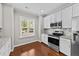 Kitchen featuring stainless steel appliances, granite countertops, white cabinets, and hardwood flooring at 265 Mariah Towns Way, Garner, NC 27529