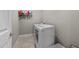 Bright laundry room with neutral tile floors, side by side washer and dryer, and white walls at 265 Mariah Towns Way, Garner, NC 27529