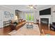 Cozy living room with a fireplace, hardwood floors, and staircase access at 265 Mariah Towns Way, Garner, NC 27529