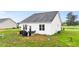 The home's rear exterior features outdoor seating and tidy landscaping at 295 Springtooth Dr, Zebulon, NC 27597