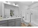 Bright bathroom featuring a double sink vanity, large mirror, and walk-in shower at 295 Springtooth Dr, Zebulon, NC 27597