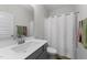 Well-lit bathroom with a single sink vanity and shower with curtain at 295 Springtooth Dr, Zebulon, NC 27597