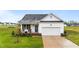 Charming single-Gathering home with a well-manicured lawn and a welcoming front porch with chairs at 295 Springtooth Dr, Zebulon, NC 27597