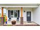 Inviting front porch with cozy seating, brick accents, and a stylish gray front door with glass at 295 Springtooth Dr, Zebulon, NC 27597