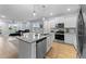 Open-concept kitchen with a granite island, stainless steel appliances, and hardwood flooring with access to Living Room at 295 Springtooth Dr, Zebulon, NC 27597