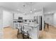 Bright kitchen featuring white cabinets, stainless steel appliances, and a granite-topped island with seating at 295 Springtooth Dr, Zebulon, NC 27597