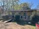 Quaint home featuring a covered front porch and ramp access, nestled in a wooded area at 308 San-Lee Drive Dr, Sanford, NC 27330