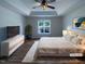 Bright main bedroom with tray ceiling, ceiling fan, and a large window overlooking the front yard at 312 Sarazen Dr, Clayton, NC 27527