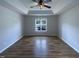 Spacious main bedroom featuring a tray ceiling, a large window, and beautiful wood floors at 312 Sarazen Dr, Clayton, NC 27527