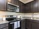 Modern kitchen features granite countertops, stainless steel appliances, and dark wood cabinets at 3521 Strawberry Patch Row, Raleigh, NC 27604
