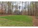 Expansive backyard featuring a lush lawn, mature trees, and partial view of the home, perfect for outdoor enjoyment at 3881 Whisperwood Ct, Youngsville, NC 27596