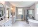 Bright bathroom featuring a large glass shower, a freestanding tub, double vanity, and modern fixtures at 3881 Whisperwood Ct, Youngsville, NC 27596