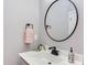 Bright bathroom featuring a vanity, round mirror, and modern faucet at 3881 Whisperwood Ct, Youngsville, NC 27596