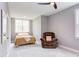 Bright bedroom features a ceiling fan, comfortable recliner, and ample natural light at 3881 Whisperwood Ct, Youngsville, NC 27596