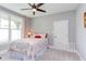 Cozy bedroom featuring a ceiling fan, quilt bedding, and large windows at 3881 Whisperwood Ct, Youngsville, NC 27596