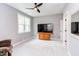 Bright bedroom with a ceiling fan, plush carpet, and a large window offering natural light at 3881 Whisperwood Ct, Youngsville, NC 27596