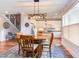 Dining area featuring a table with chairs, a modern light fixture, and access to the kitchen and living area at 3881 Whisperwood Ct, Youngsville, NC 27596
