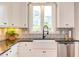 Bright kitchen with a white farmhouse sink, matte black faucet, and stainless steel appliances at 3881 Whisperwood Ct, Youngsville, NC 27596