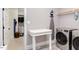 Convenient laundry room with washer, dryer, ironing board and doorway to closet at 3881 Whisperwood Ct, Youngsville, NC 27596