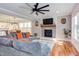 Bright living room featuring a fireplace, large sectional, and hardwood floors that flow into an eat-in kitchen at 3881 Whisperwood Ct, Youngsville, NC 27596