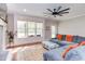 Bright living room featuring a large sectional, hardwood floors, and a wall of windows overlooking the outdoors at 3881 Whisperwood Ct, Youngsville, NC 27596