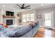 Bright living room featuring a fireplace, large sectional, hardwood floors, and large windows with a window seat at 3881 Whisperwood Ct, Youngsville, NC 27596