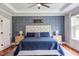 Spacious main bedroom featuring a tray ceiling, hardwood floors, statement wallpaper, and a king sized bed at 3881 Whisperwood Ct, Youngsville, NC 27596