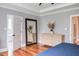 Spacious main bedroom featuring hardwood floors, a dresser, and an open door to an en suite bathroom at 3881 Whisperwood Ct, Youngsville, NC 27596