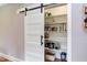 Pantry with white shelves and a sliding barn door provides ample storage at 3881 Whisperwood Ct, Youngsville, NC 27596