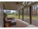 Inviting covered porch featuring comfortable seating and views of the lush, green backyard and neighborhood at 3881 Whisperwood Ct, Youngsville, NC 27596