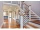 Open concept staircase with hardwood steps, light gray walls, and modern railing at 3881 Whisperwood Ct, Youngsville, NC 27596