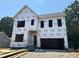 Exterior of new construction home with installed Tyvek HomeWrap, showing framed window and door openings at 406 Columbia Dr, Raleigh, NC 27604