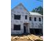 Two-story home during construction with wood stacked in the front yard and ladders leaning on the side at 406 Columbia Dr, Raleigh, NC 27604