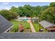 Expansive backyard aerial view featuring a pool, outdoor kitchen, fireplace, and lush landscaping, perfect for entertaining at 4769 Swordfish Dr, Raleigh, NC 27603