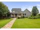 Large backyard with a stone walkway, home, pergola and lush landscaping at 4769 Swordfish Dr, Raleigh, NC 27603