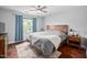 Bright bedroom with hardwood floors, ceiling fan, large window with curtains, and a warm rug at 4769 Swordfish Dr, Raleigh, NC 27603